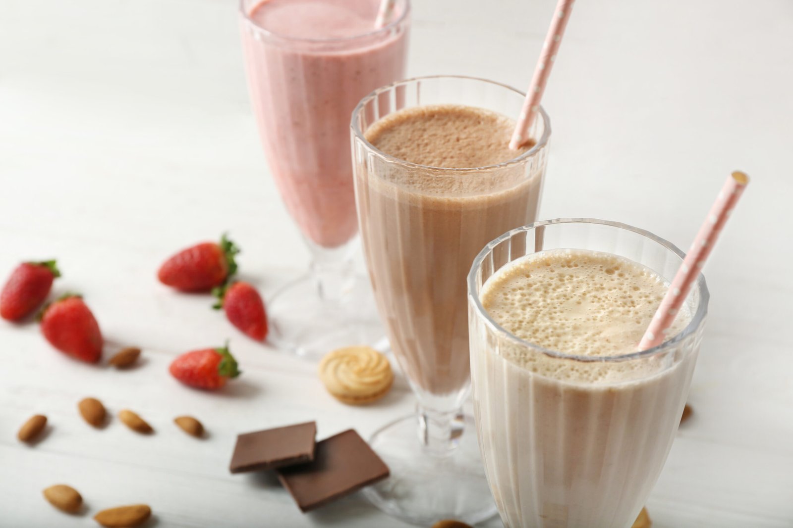 tasty cocktails with fresh berries and sweets on wooden background